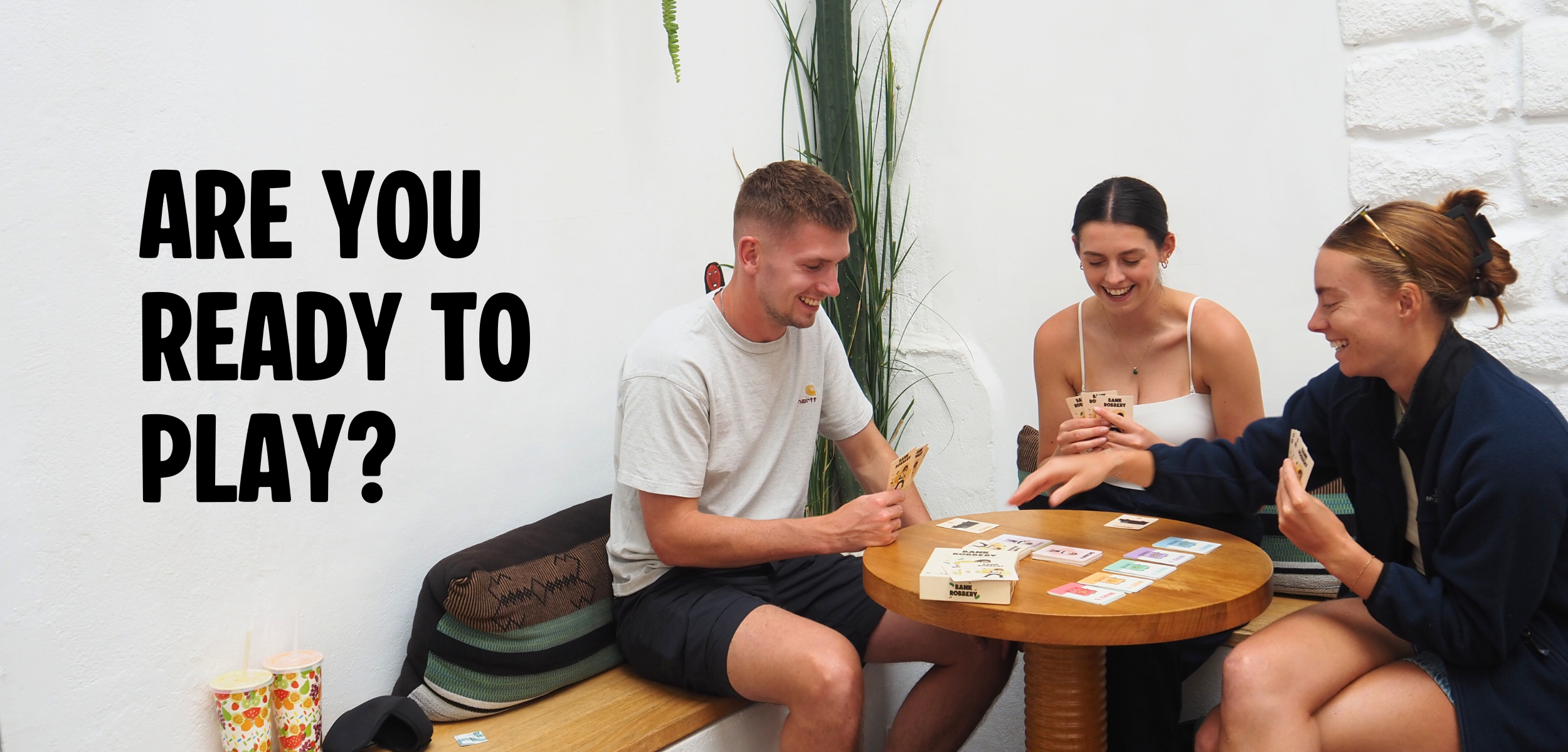 Three people playing a card game together with text 'Are you ready to play?'